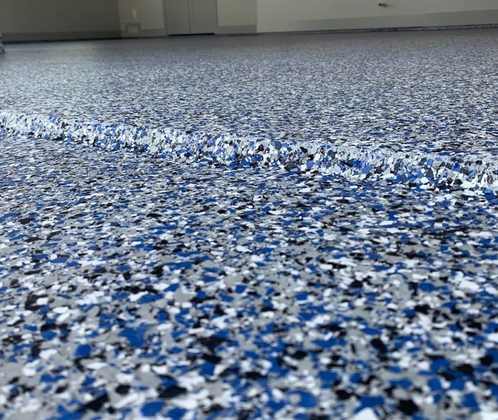 blue white and grey chips on epoxy floor in a garage